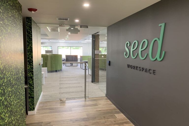 Entrance to 'seed workspace' with green branding and a leafy wall decoration.