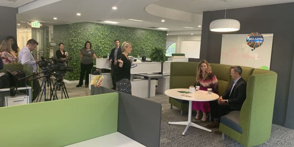 A business meeting in progress in an office decorated with green walls and furniture.
Title: Office Meeting with Green Design Elements