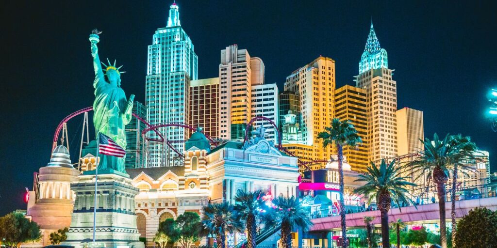 Nighttime view of Las Vegas Strip with illuminated replicas of iconic landmarks.