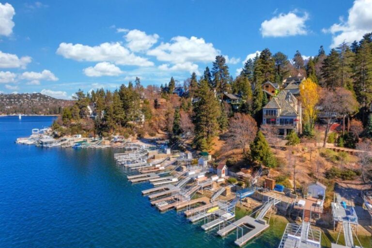 Aerial view of lakefront properties with private docks along a clear blue lake.