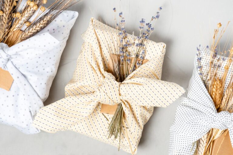 Eco-friendly gift wrapping with dried flowers and wheat in beige, polka-dotted, and striped cloth.