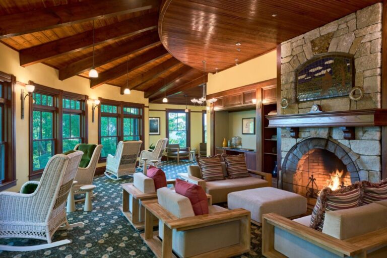 A cozy lodge room with wooden rocking chairs, a stone fireplace, and a warm, inviting ambiance.