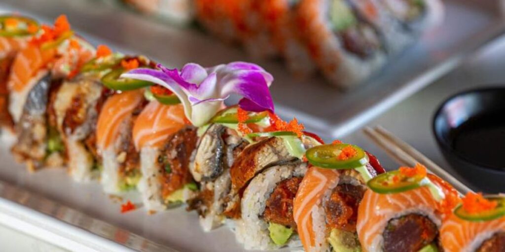 Colorful sushi rolls elegantly plated with vibrant garnishes.