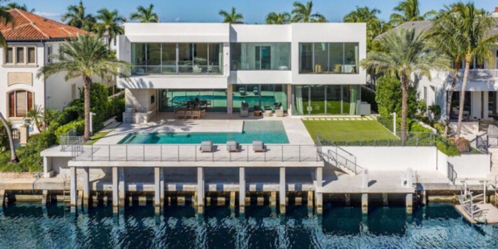 A luxurious modern waterfront house with a pool and private dock.