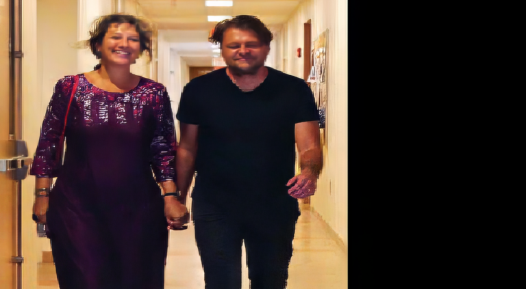 Photo of Emanuele and Ilaria holding hands walking down a hallway.
