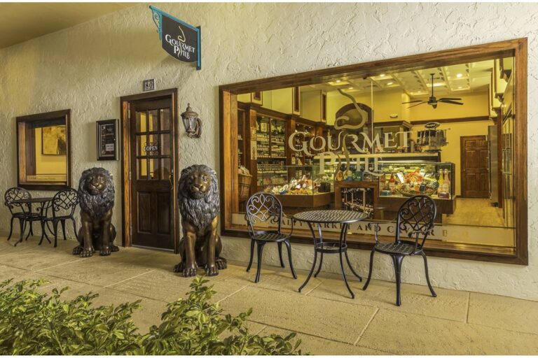 Exterior view of 'Gourmetphile' delicatessen with elegant lion statues guarding the entrance.