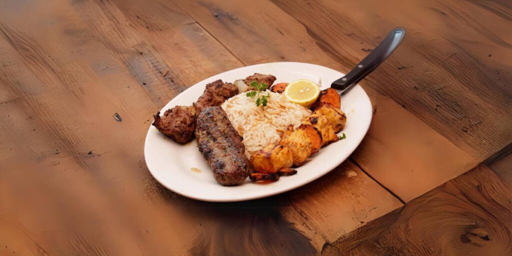 A plate of Mediterranean mixed grill with seasoned kebabs, grilled chicken, and rice garnished with lemon and parsley.